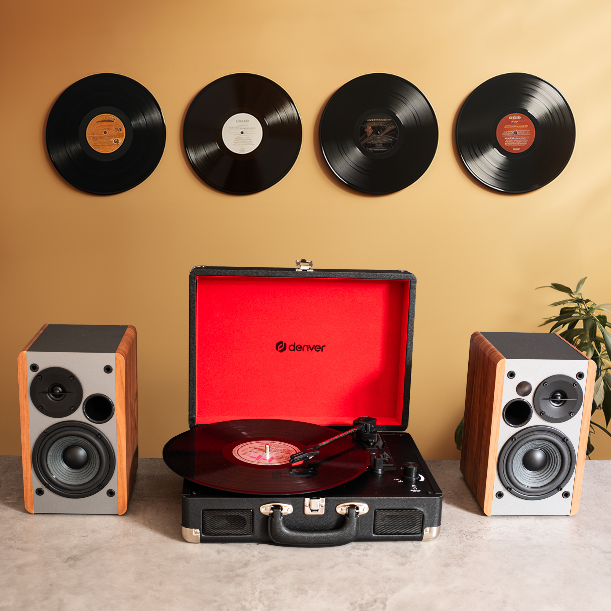 Gramofon z głośnikami, płyty winylowe na ścianie, na beżowym tle.