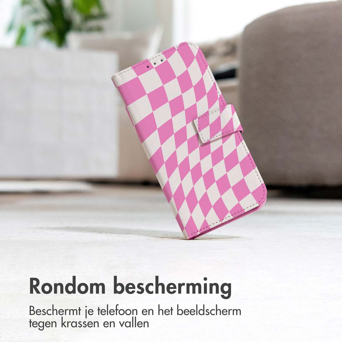 Een telefoonhoesje, roze en wit geruit patroon, op een houten vloer.