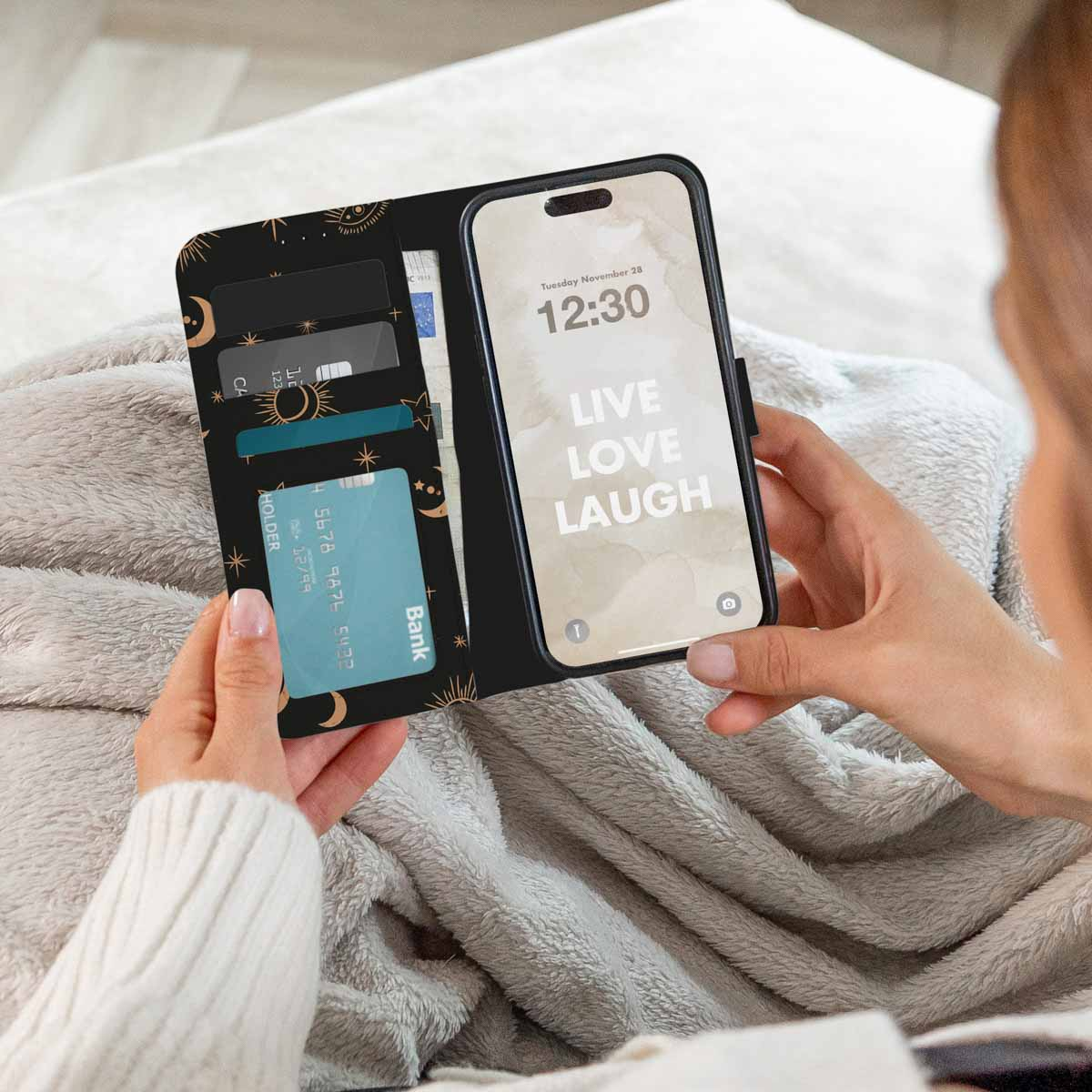 Een vrouw houdt een telefoonhoes vast. De telefoon toont 'Live, Love, Laugh'. Hoes heeft kaartsleuven.