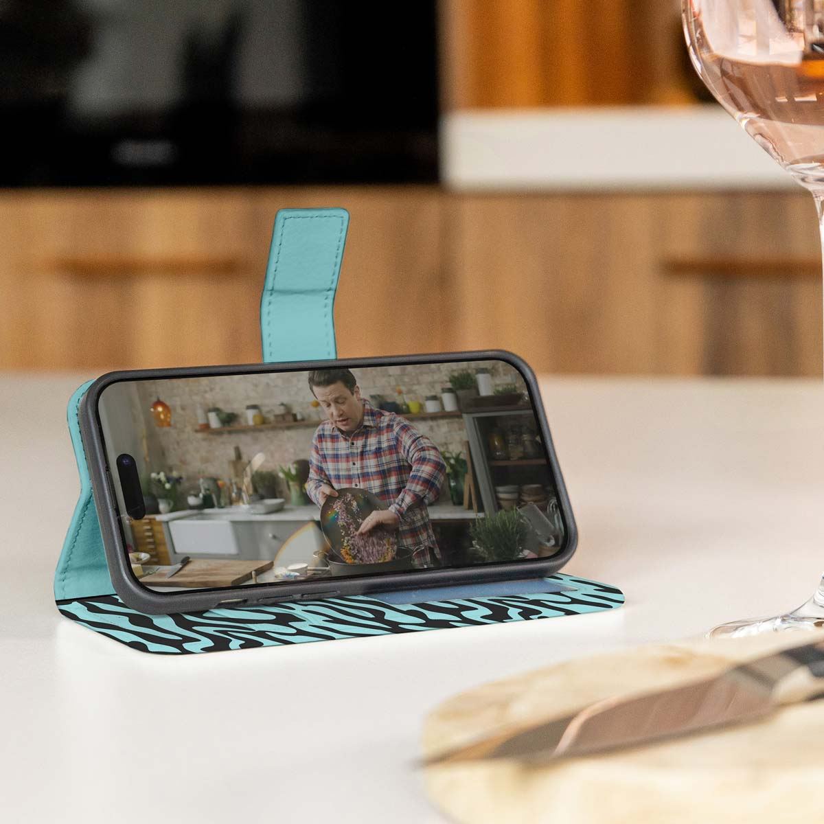 Telefoonhoesje opengeklapt, met een zebraprintpatroon, met een man op de achtergrond.