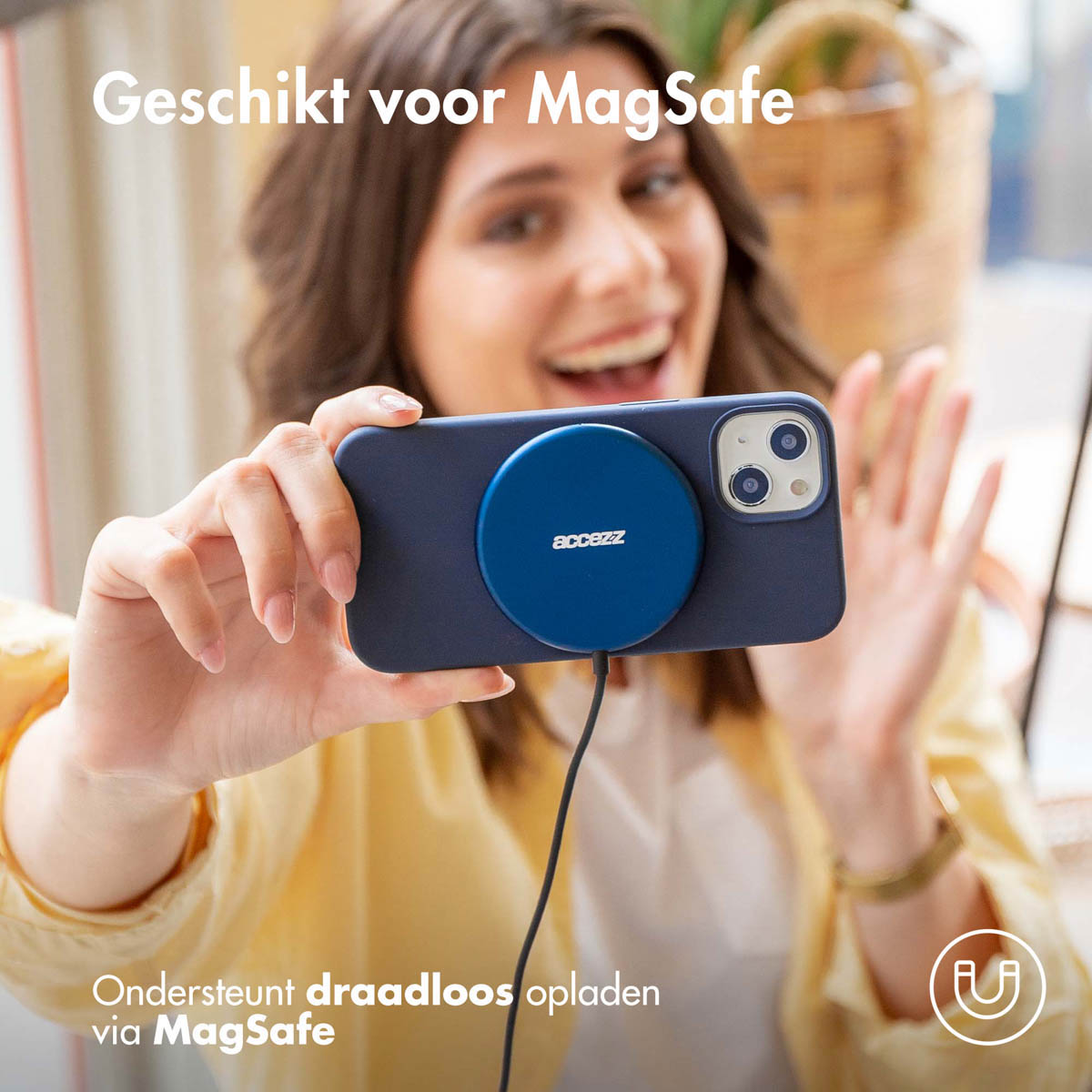 Eine Frau hält ein Telefon mit einem blauen MagSafe-Ladegerät. Auf dem Telefon ist eine blaue Hülle.