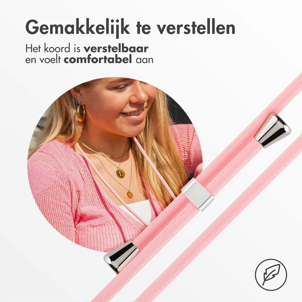 Eine Frau mit rosa Pullover und Goldschmuck. Rosa Kordeln mit silbernen Akzenten im Vordergrund.