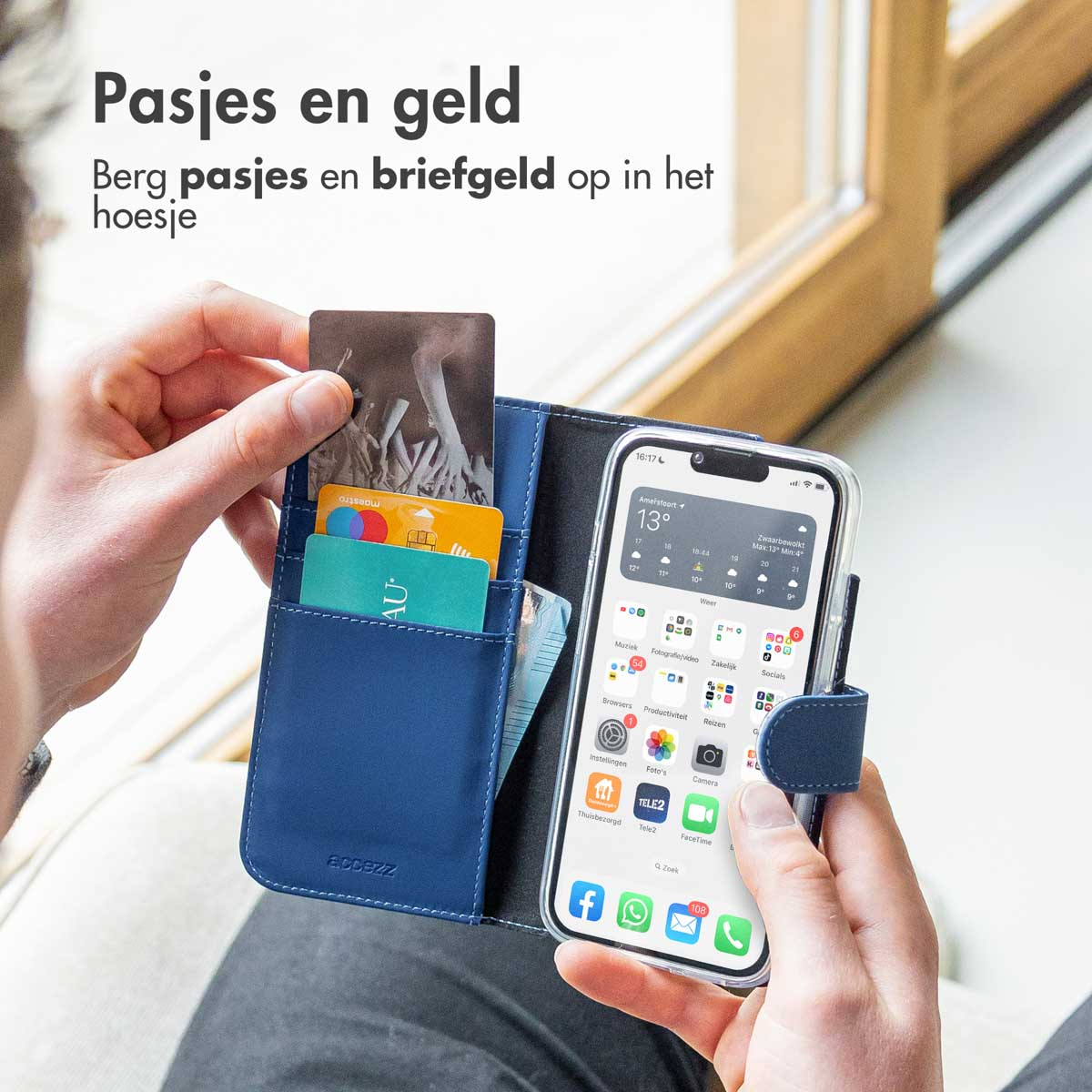 Une personne tient un étui de téléphone bleu avec une section portefeuille remplie de cartes. Fond flou.