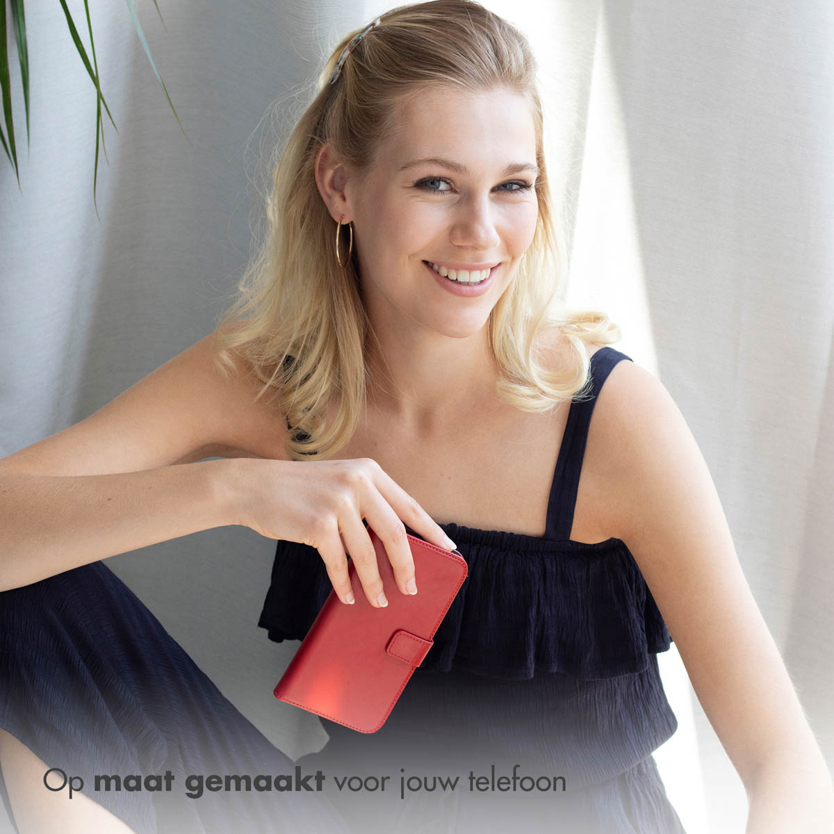 Een vrouw die een rode telefoonhoes vasthoudt. Ze glimlacht. De tekst staat onderaan.