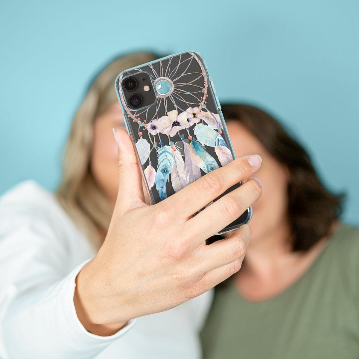 Twee vrouwen die een telefoon met dromenvangerdesign vasthouden, een selfie maken.