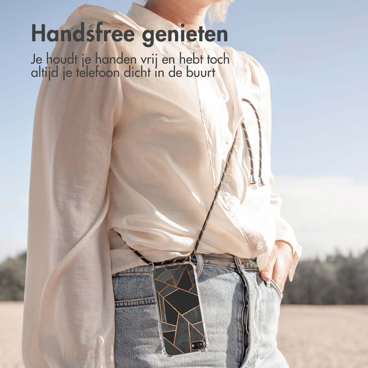 Vrouw met een telefoonhoesje met een bandje. De hoes heeft een geometrisch ontwerp.