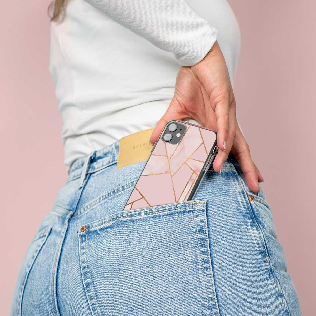 Ein Telefon in einer Tasche. Rosa Handyhülle mit goldenem Design. Jeans-Tasche, rosa Hintergrund.