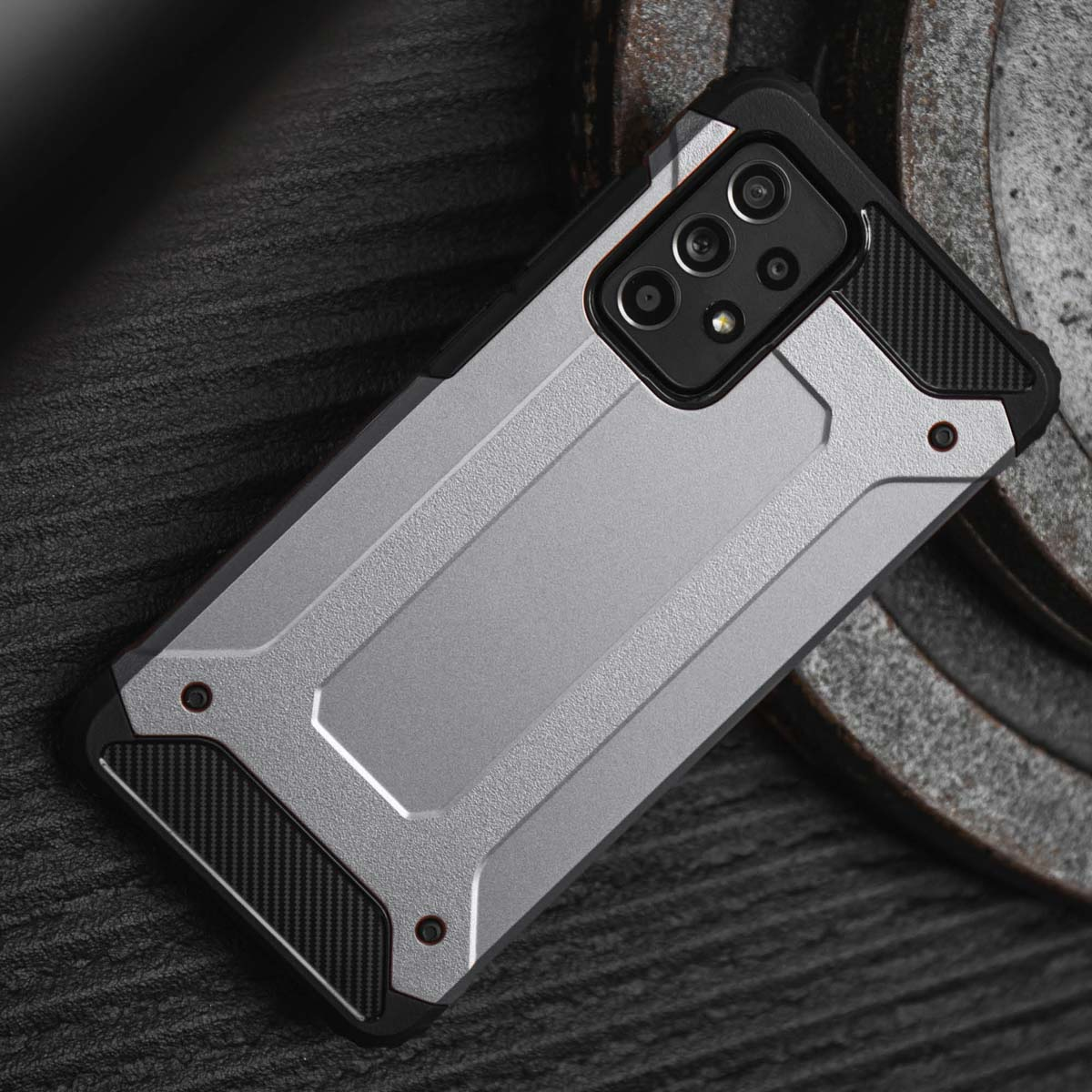 Coque de téléphone argentée et noire sur une surface texturée. Design robuste.