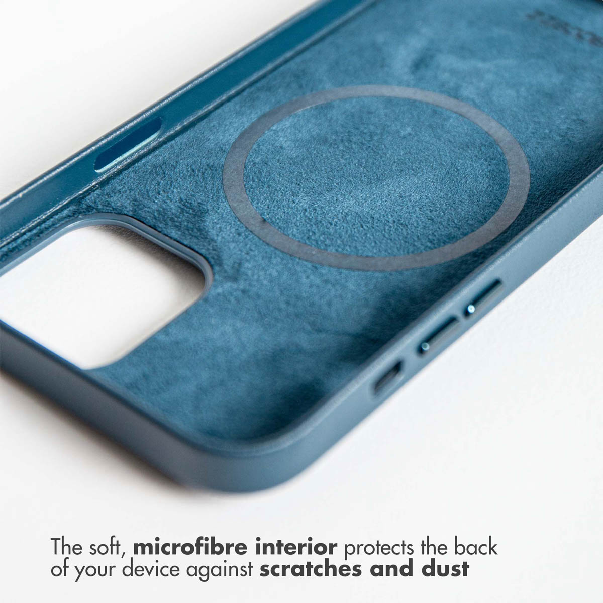 Close-up van een blauwe telefoonhoes binnenkant met een cirkelvormig ontwerp en tekst over microvezel.