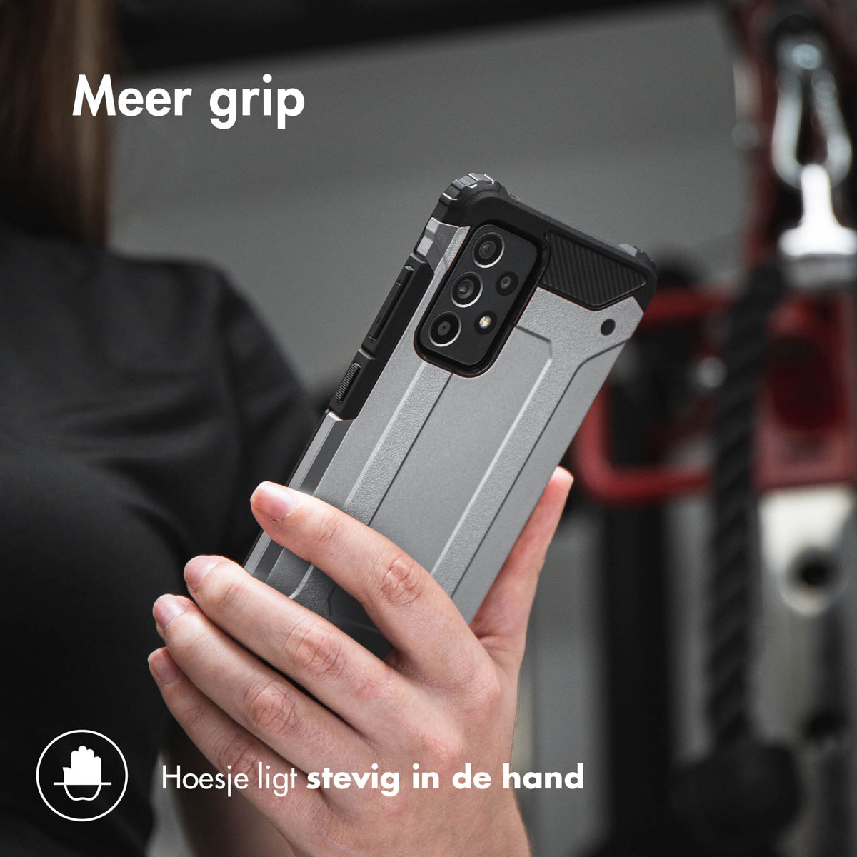 Main tenant un téléphone dans un étui protecteur argenté et noir. L'étui a un design robuste.