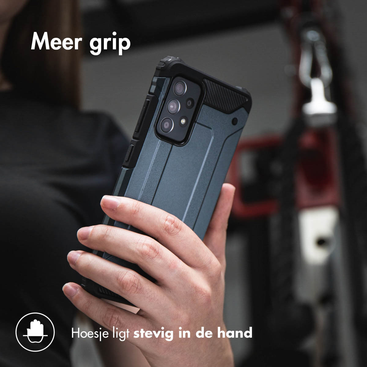 Une personne tient un téléphone dans un étui bleu avec une prise noire. L'arrière-plan est flou.