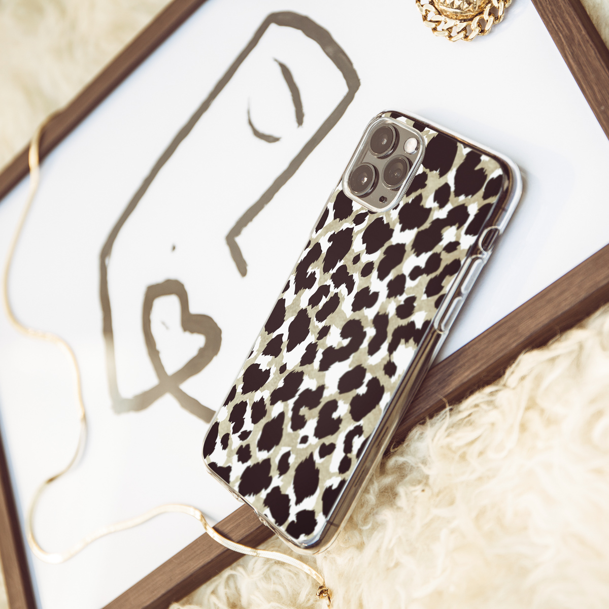 Coque de téléphone avec un motif léopard, posée sur une surface blanche.