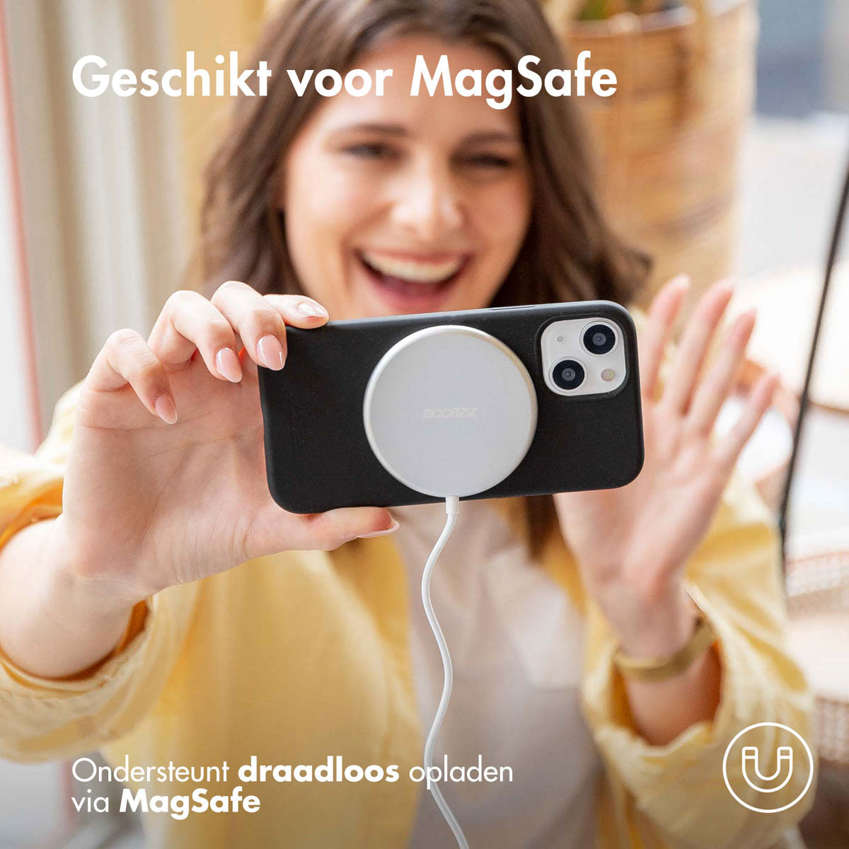 Vrouw die een telefoon met MagSafe-lader vasthoudt.