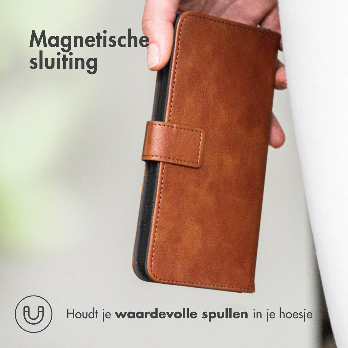 Eine braune Leder-Handyhülle. Sie wird von einer Hand gehalten. Der Text lautet: "Magnetverschluss".