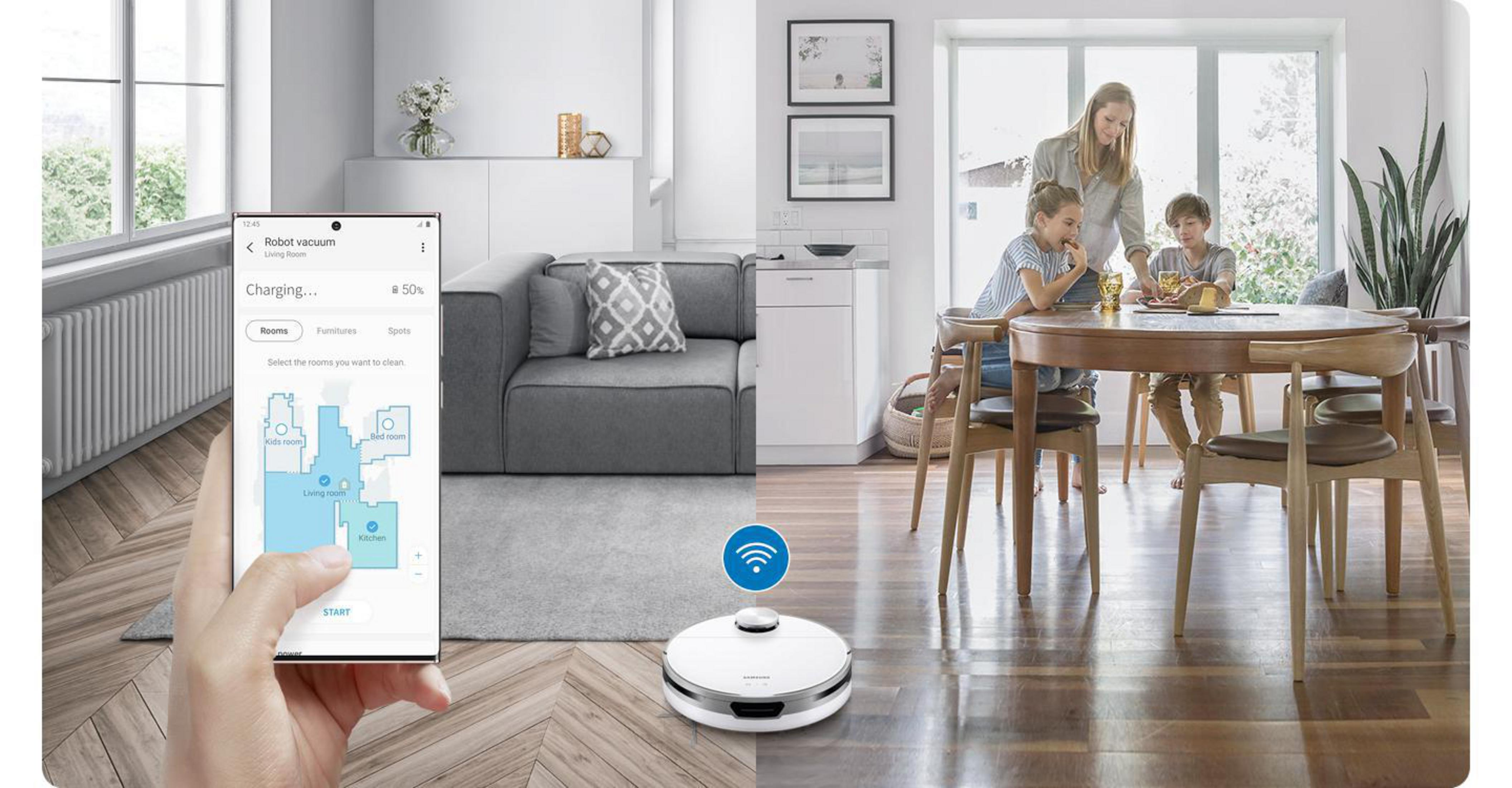 Robot sprzątający czyści drewnianą podłogę. Telefon wyświetla mapę. Rodzina w kuchni/salonie.