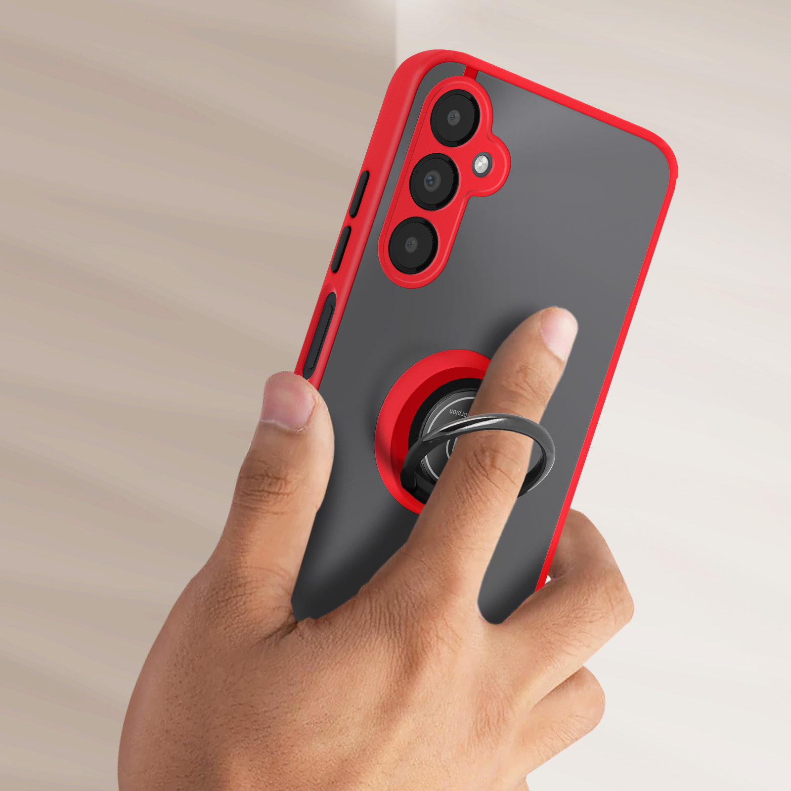 Mano che tiene la custodia del telefono. Custodia rossa e grigia, supporto ad anello, tre fotocamere, sfondo neutro.
