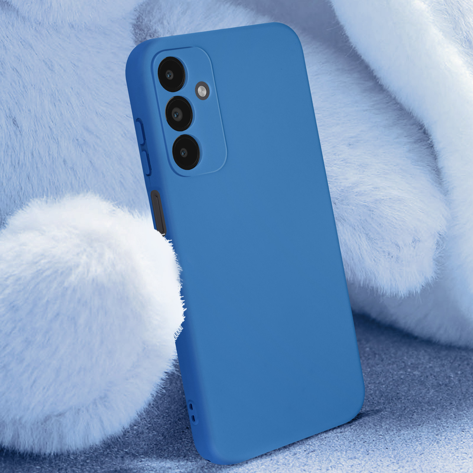 Una custodia blu per telefono tenuta contro un oggetto bianco e soffice, che mostra tre cerchi per la fotocamera.