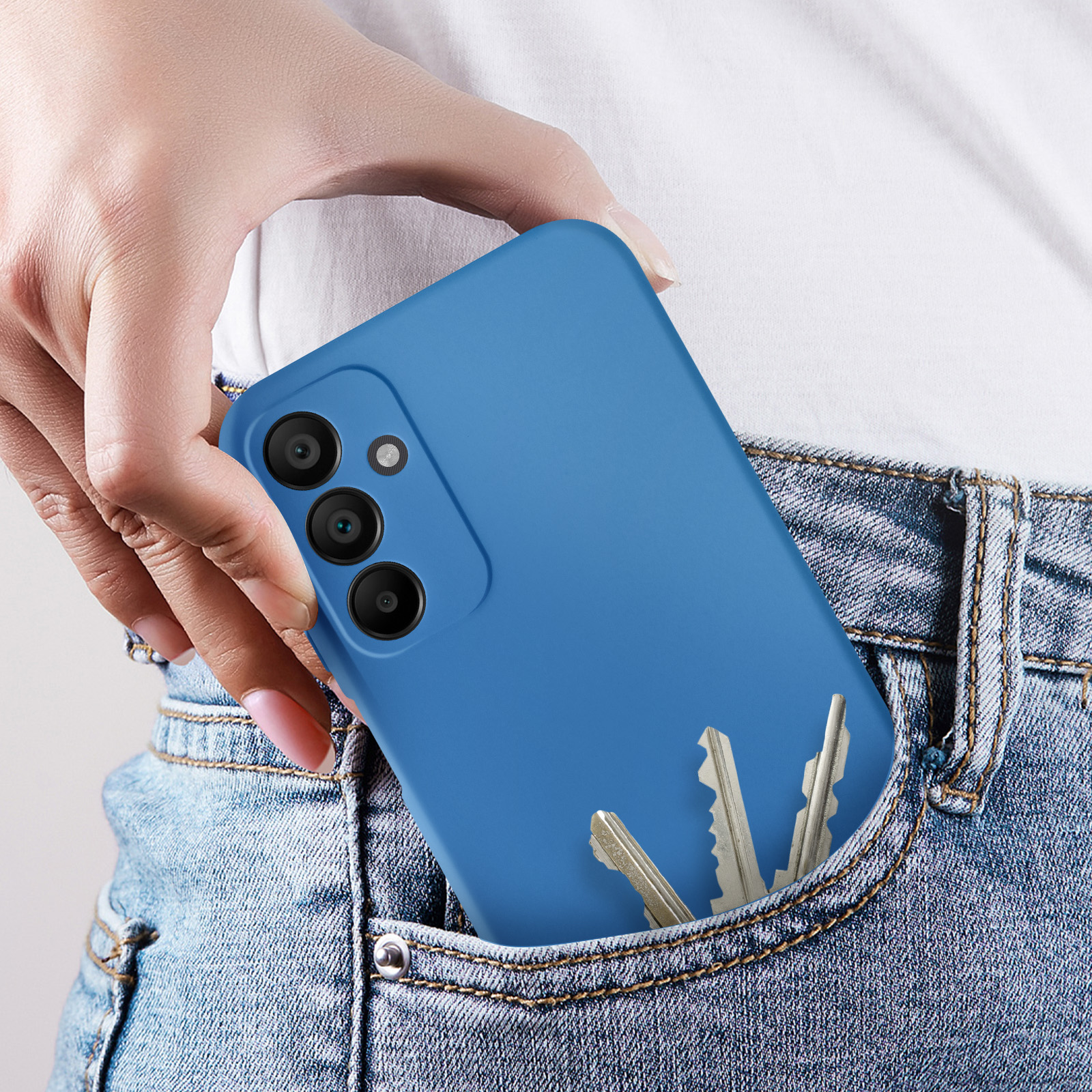 Una custodia blu per telefono in una tasca di jeans. Le chiavi sono visibili. Sfondo jeans.