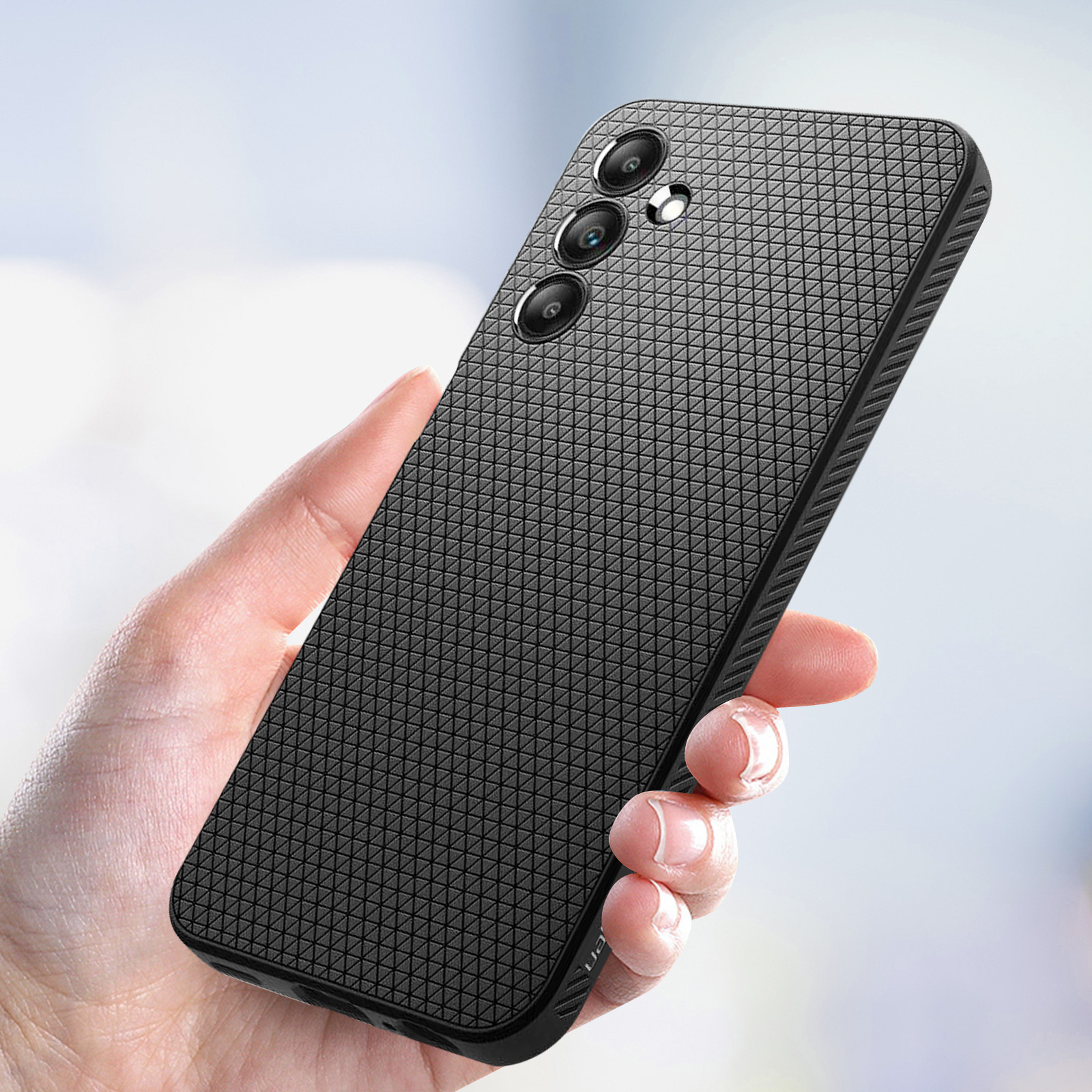Osoba trzymająca czarne etui na telefon z fakturą i obiektywami potrójnego aparatu.
