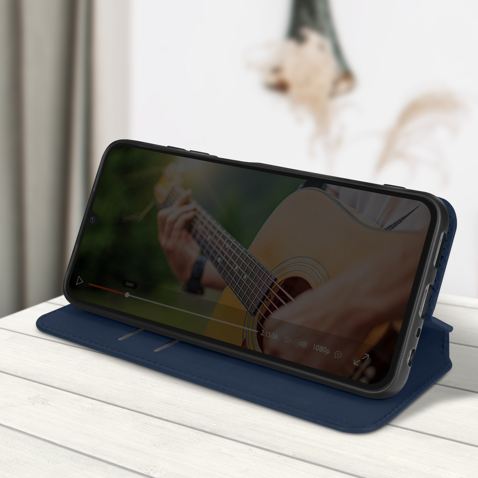 Una custodia per telefono blu aperta che mostra un telefono che riproduce un video di una persona che suona la chitarra.