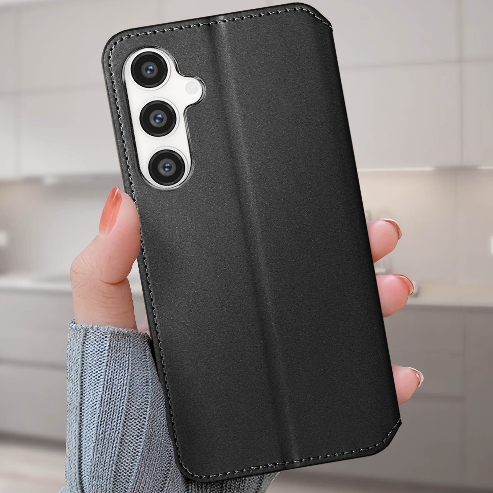 Custodia nera per telefono con tre obiettivi della fotocamera. Persona che tiene la custodia.