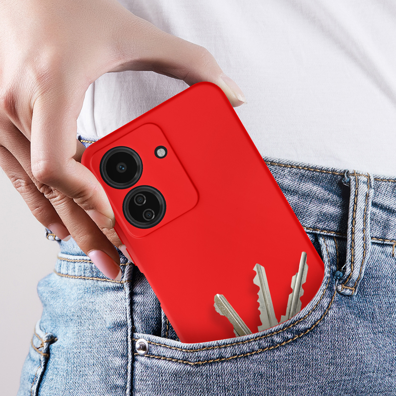 Una custodia rossa per telefono in una tasca di jeans. Anche le chiavi sono nella tasca.