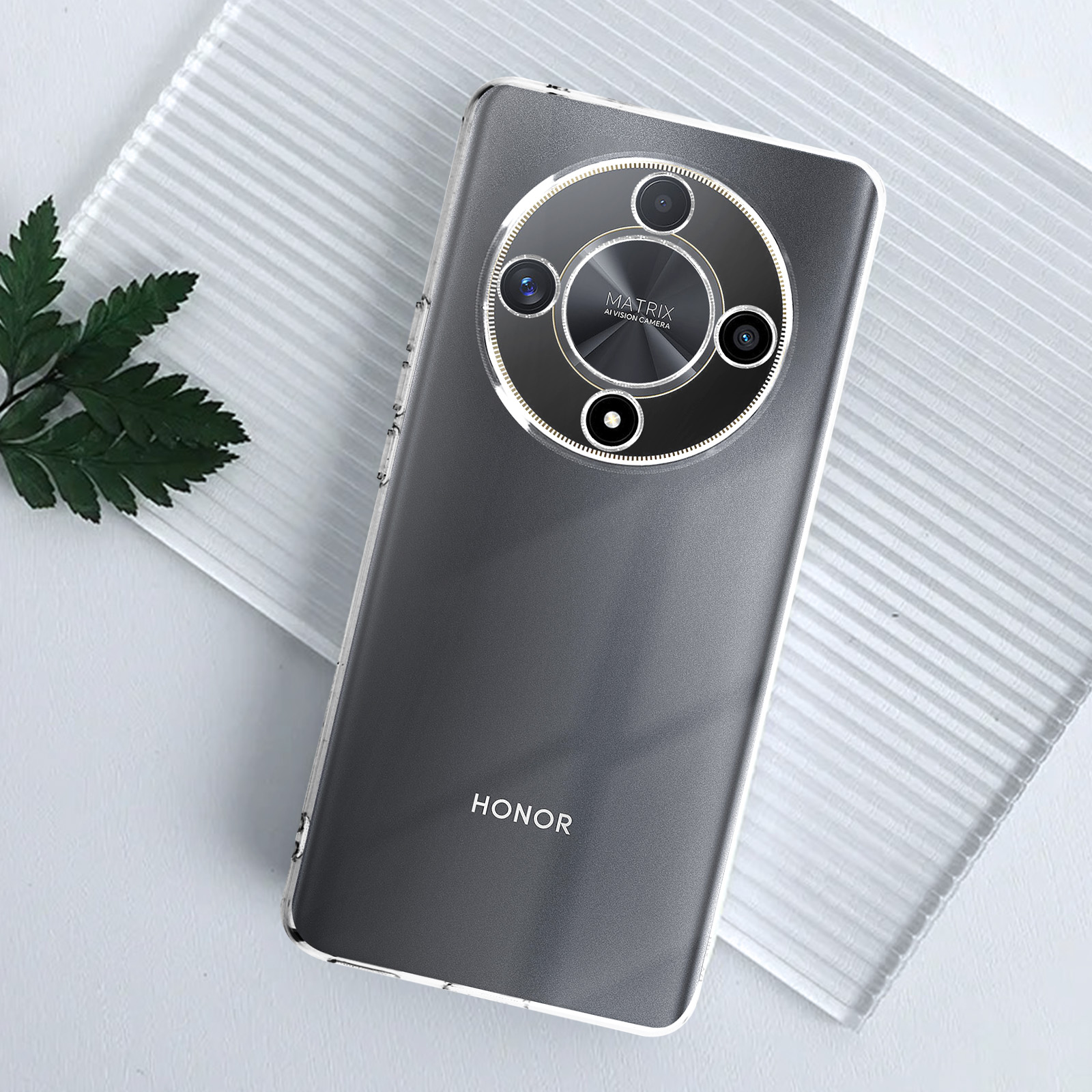 Un telefono grigio con più fotocamere. La custodia è trasparente e dice HONOR.