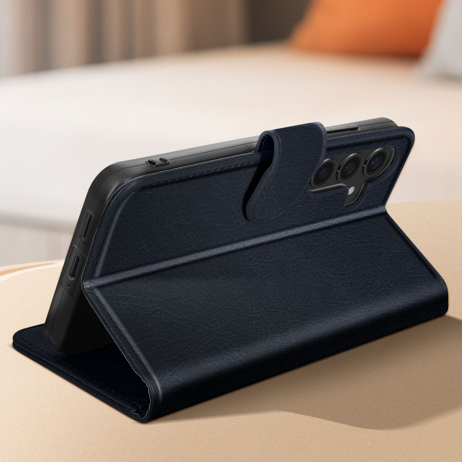 Custodia nera per telefono su un tavolo, aperta per rivelare un telefono. Sfondo della camera da letto sfocato.