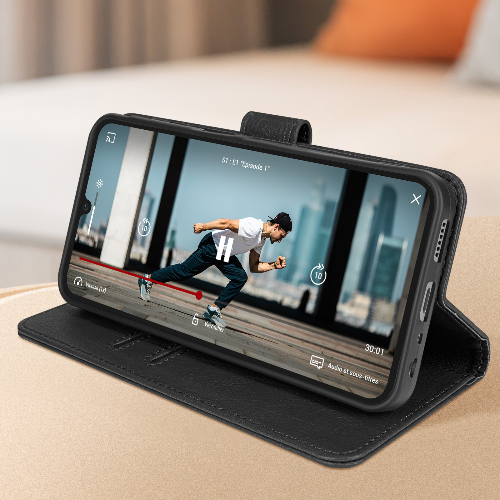 Ein Telefon, das ein Video anzeigt, geöffnet in einer schwarzen Hülle. Ein Mann rennt auf dem Bildschirm.