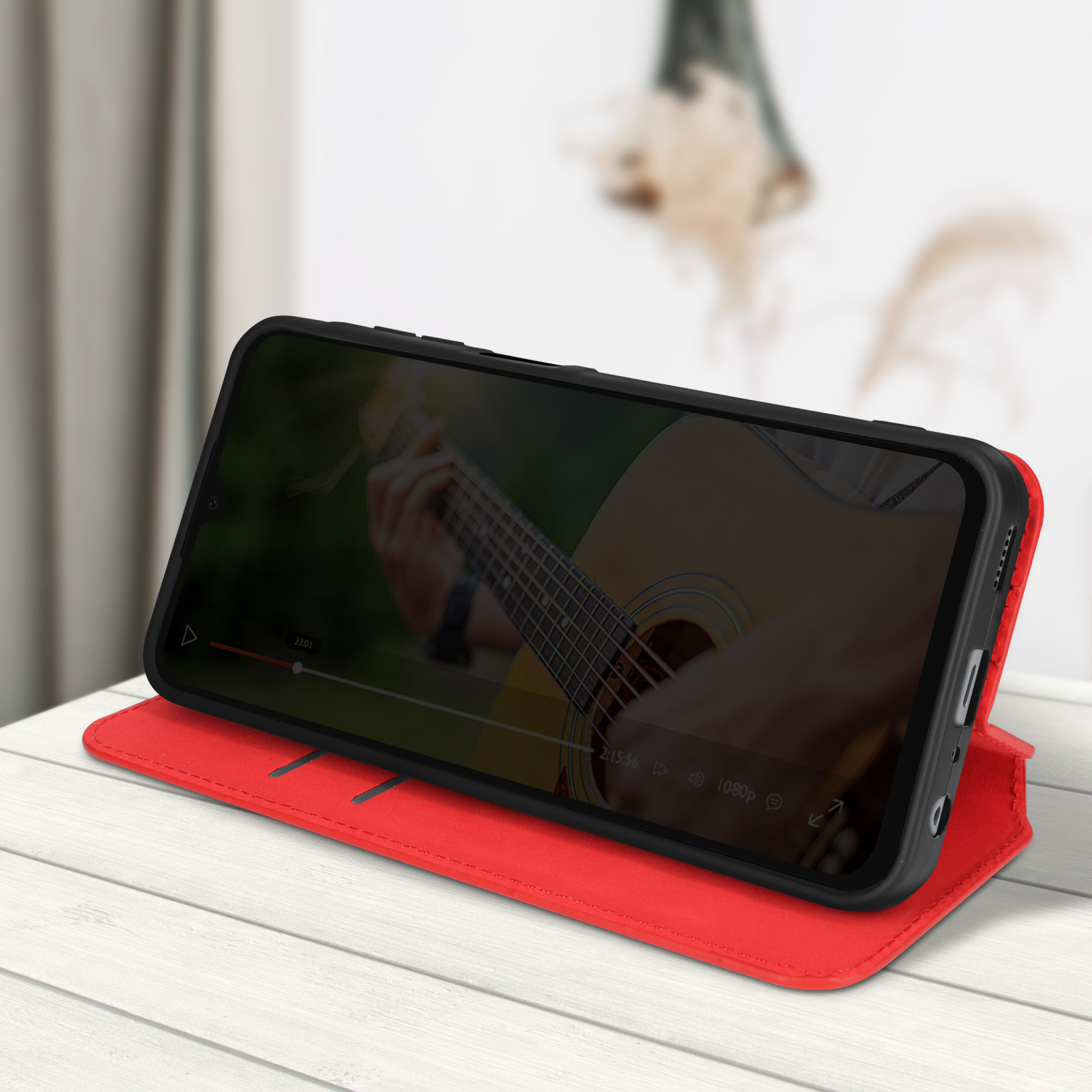 Telefono in una custodia rossa che mostra un video con un chitarrista.
