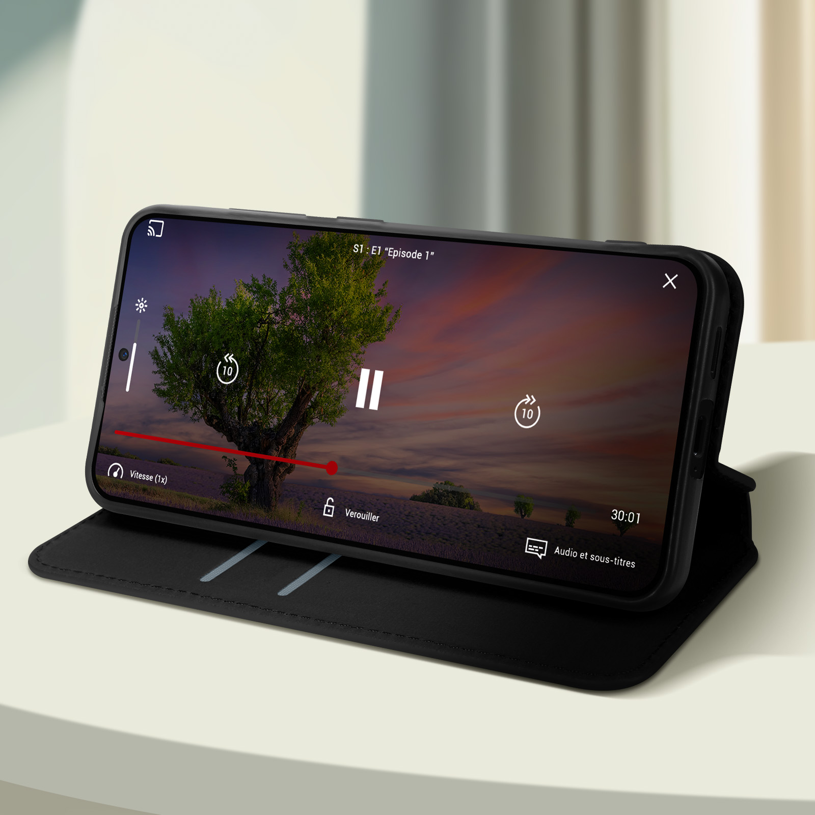 Un telefono che mostra un video su una custodia su una scrivania con sfondo sfocato.