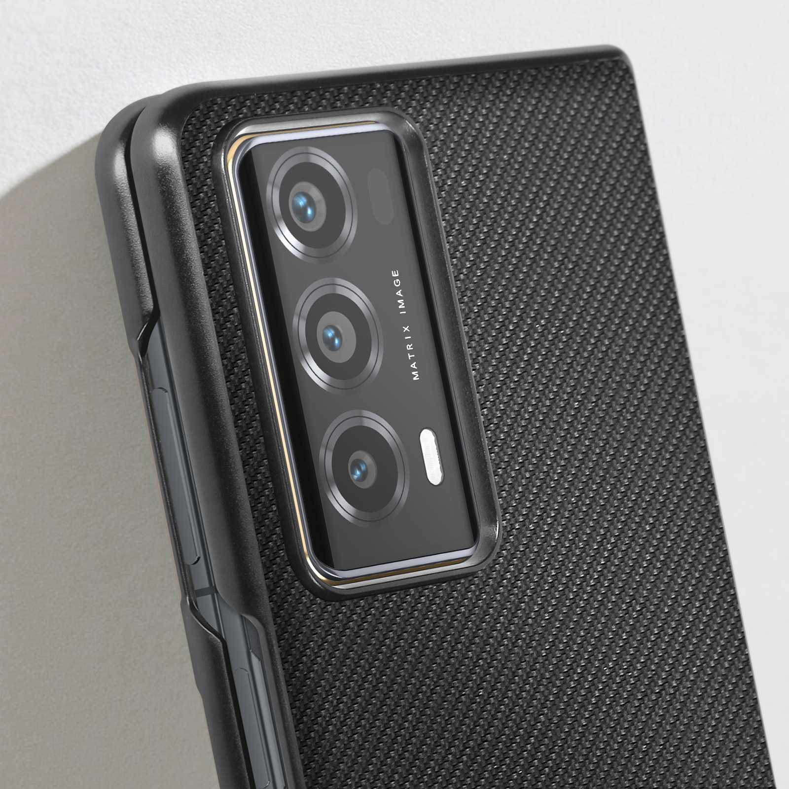 Primo piano di un telefono con retro strutturato e modulo fotocamera con più lenti, custodia nera.