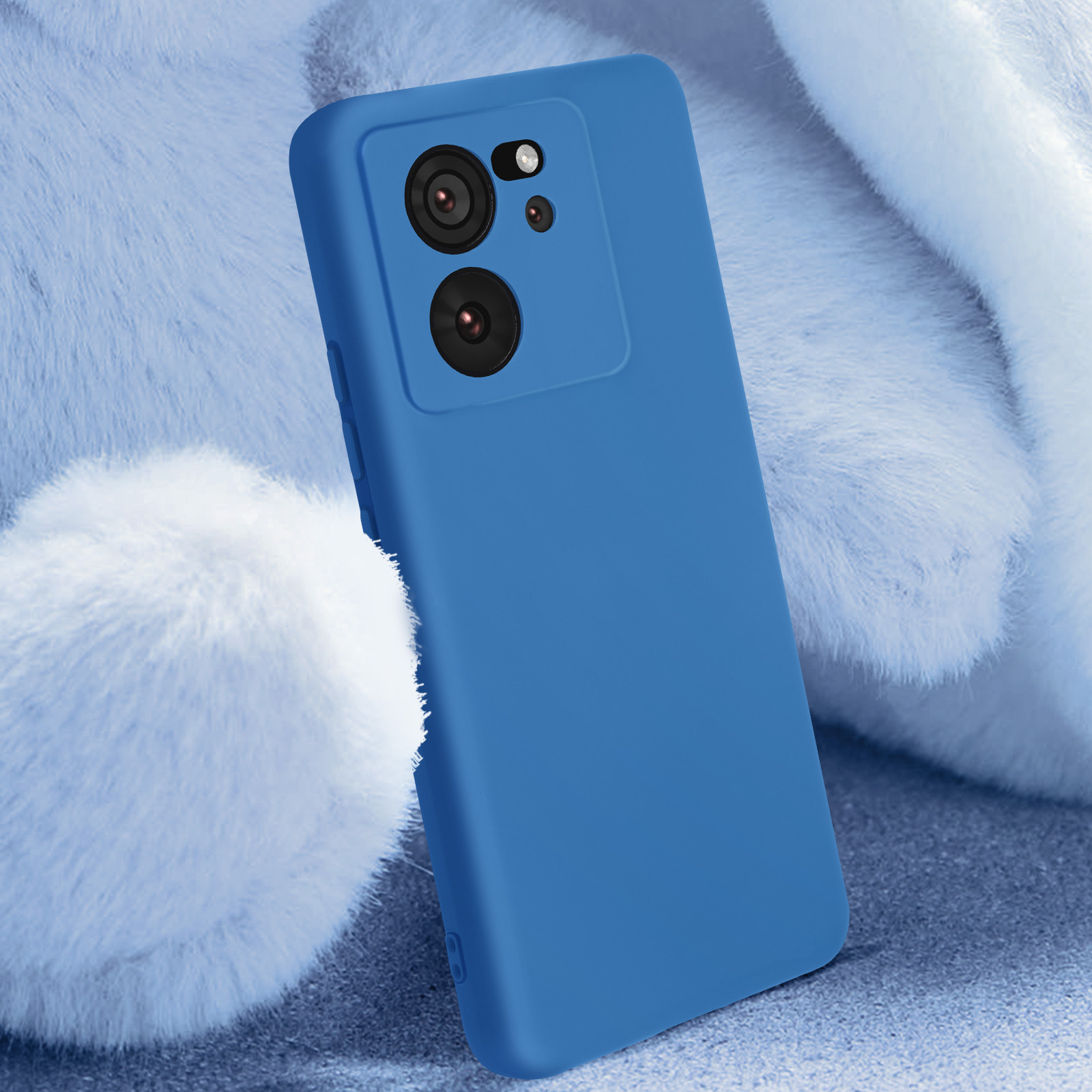 Custodia blu per telefono con ritagli per fotocamera, su superficie bianca e soffice.