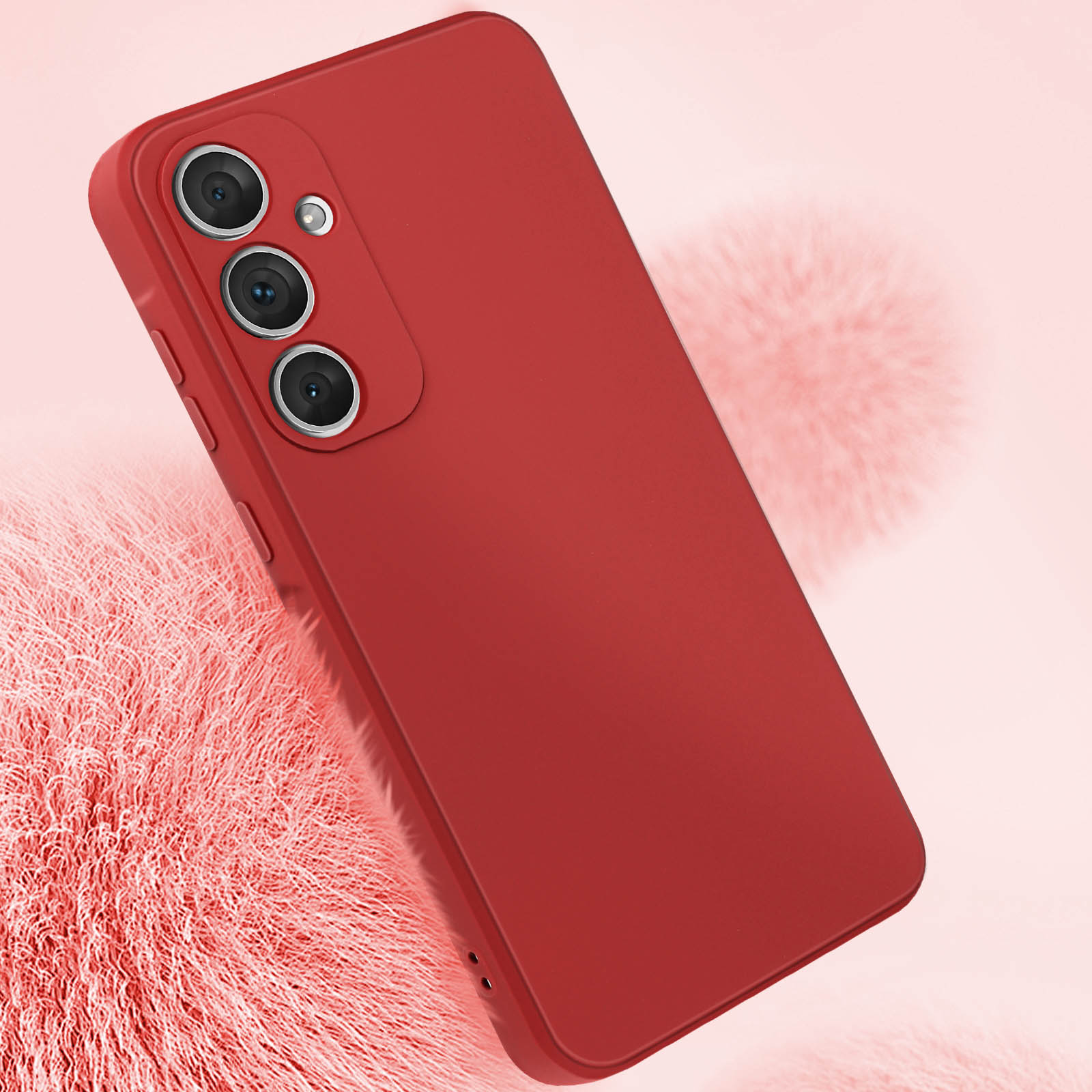 Custodia rossa per telefono. Tre obiettivi della fotocamera. Sfondo rosa con una trama soffice.