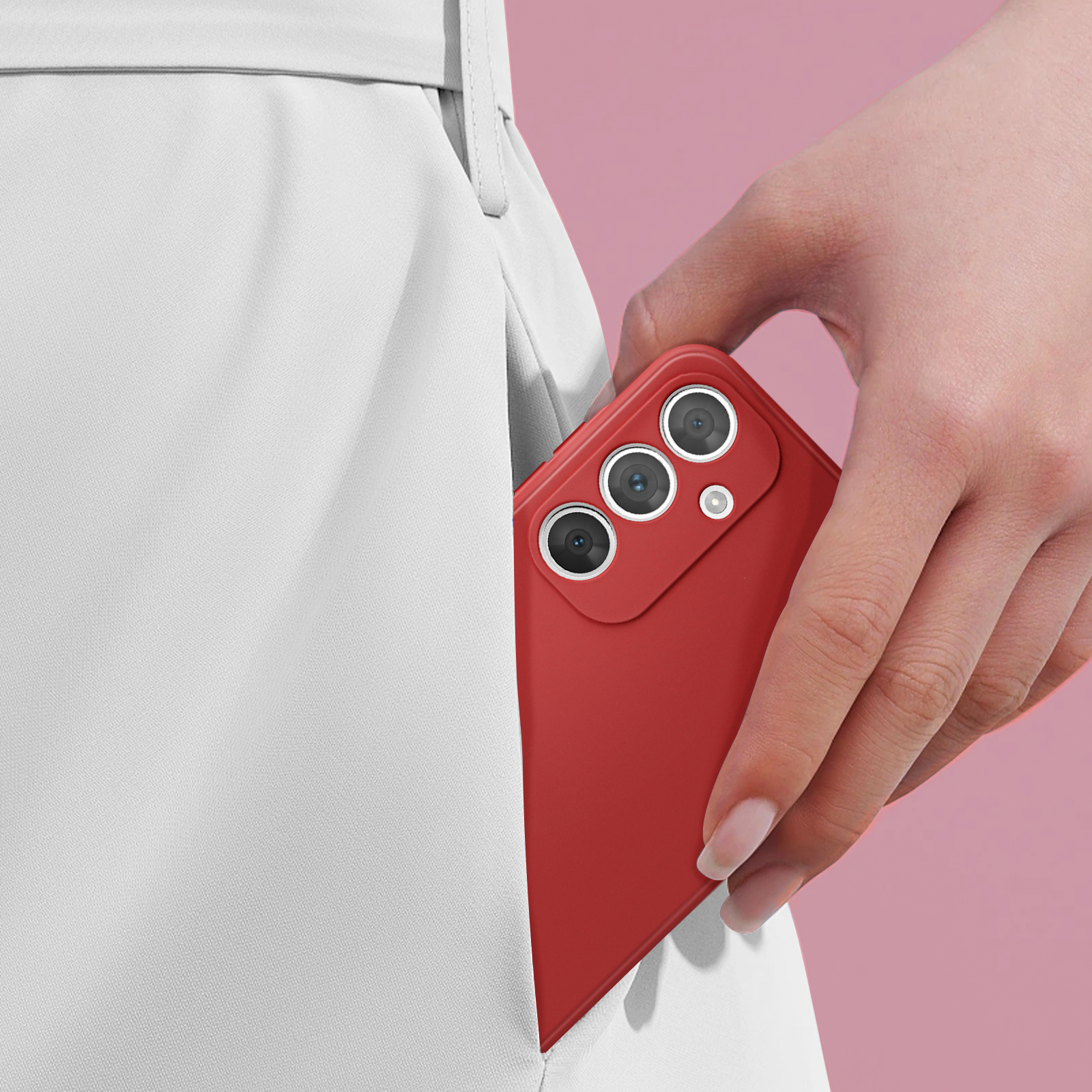 La mano di una persona che inserisce un telefono rosso in una custodia rossa. Lo sfondo è una superficie rosa.