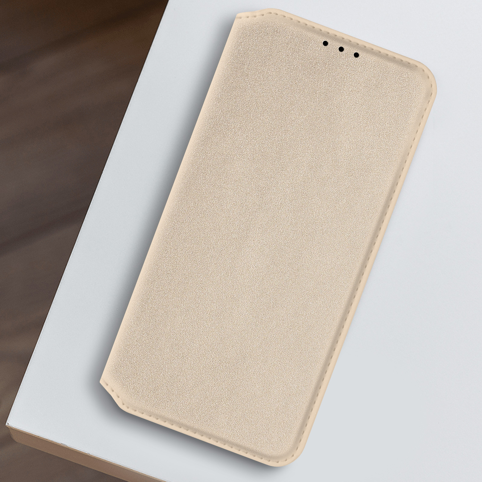 Custodia beige per telefono, chiusa. La custodia è su una superficie bianca.