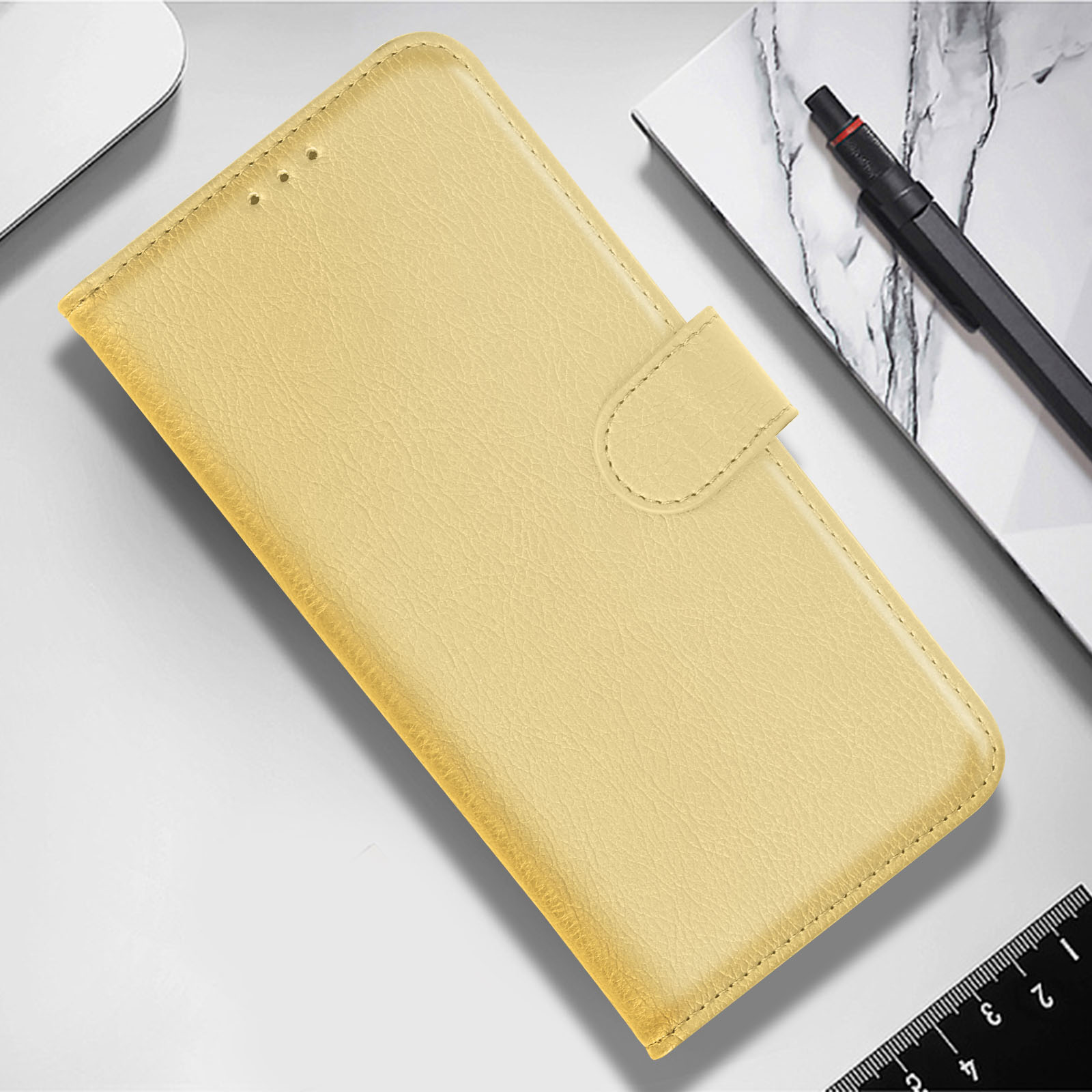 Funda de teléfono amarilla cerrada, con un botón. La funda está sobre una superficie blanca.