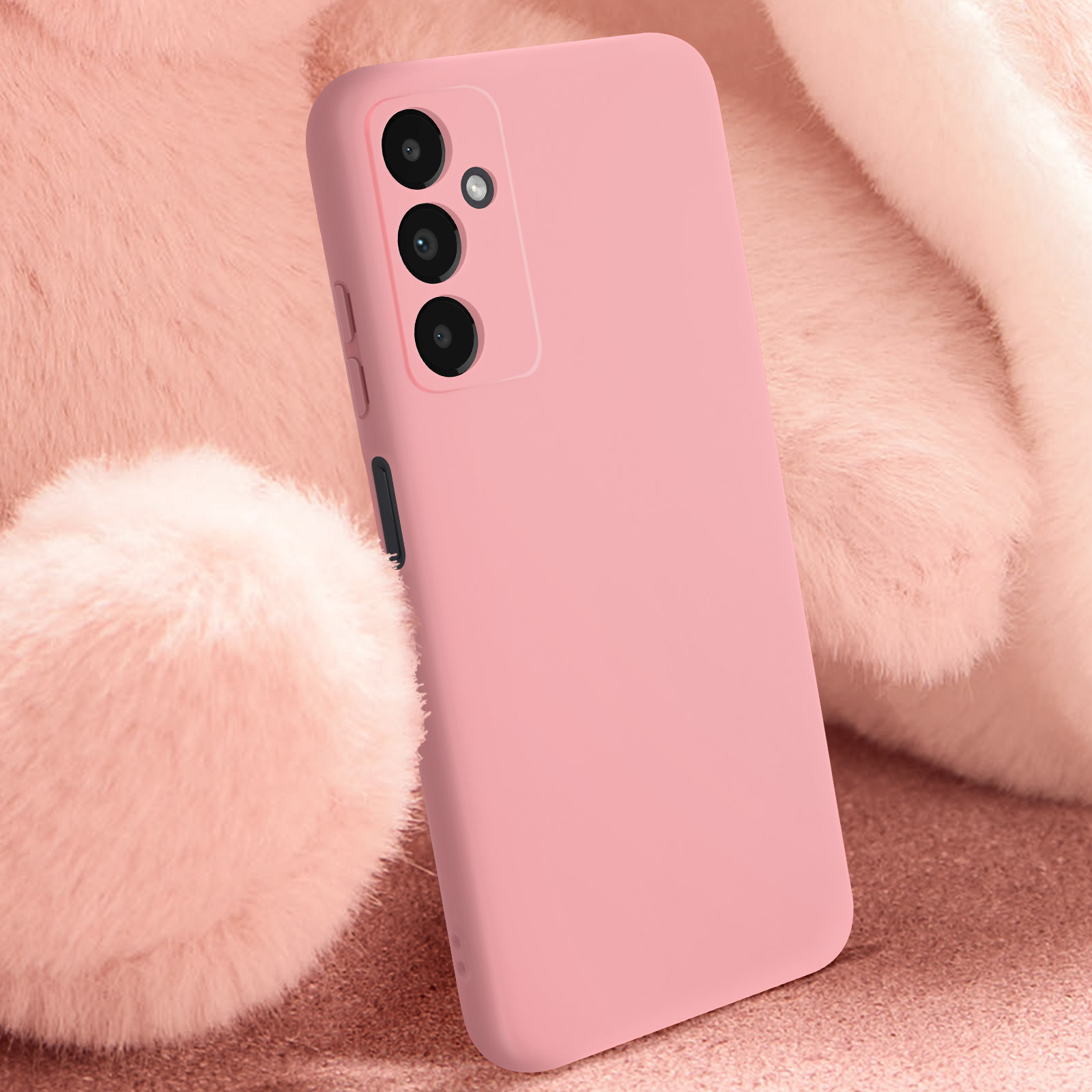 Coque de téléphone rose avec trois caméras. La coque repose sur une surface rose et moelleuse.