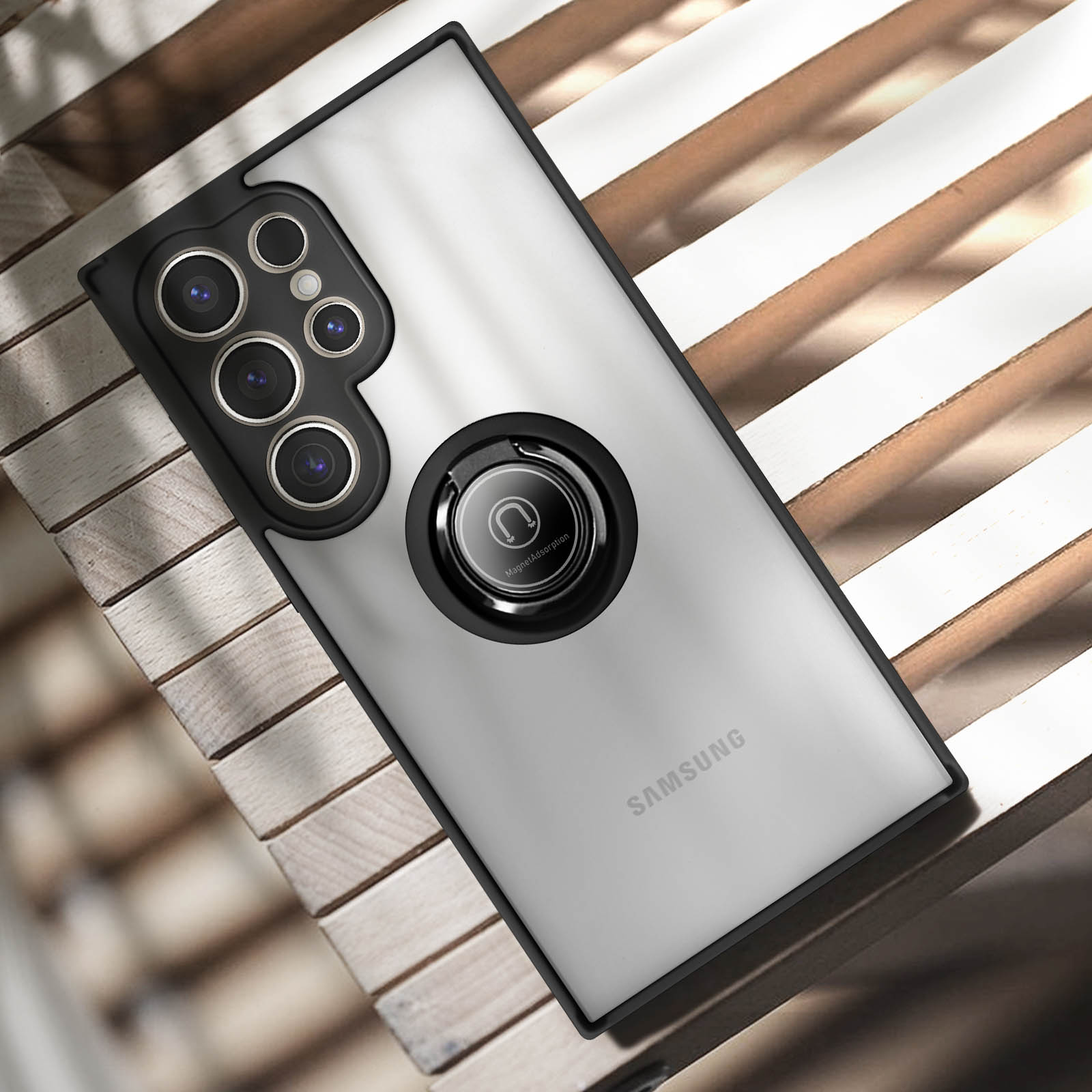 Smartphone con custodia nera, supporto ad anello e più lenti della fotocamera su doghe di legno.