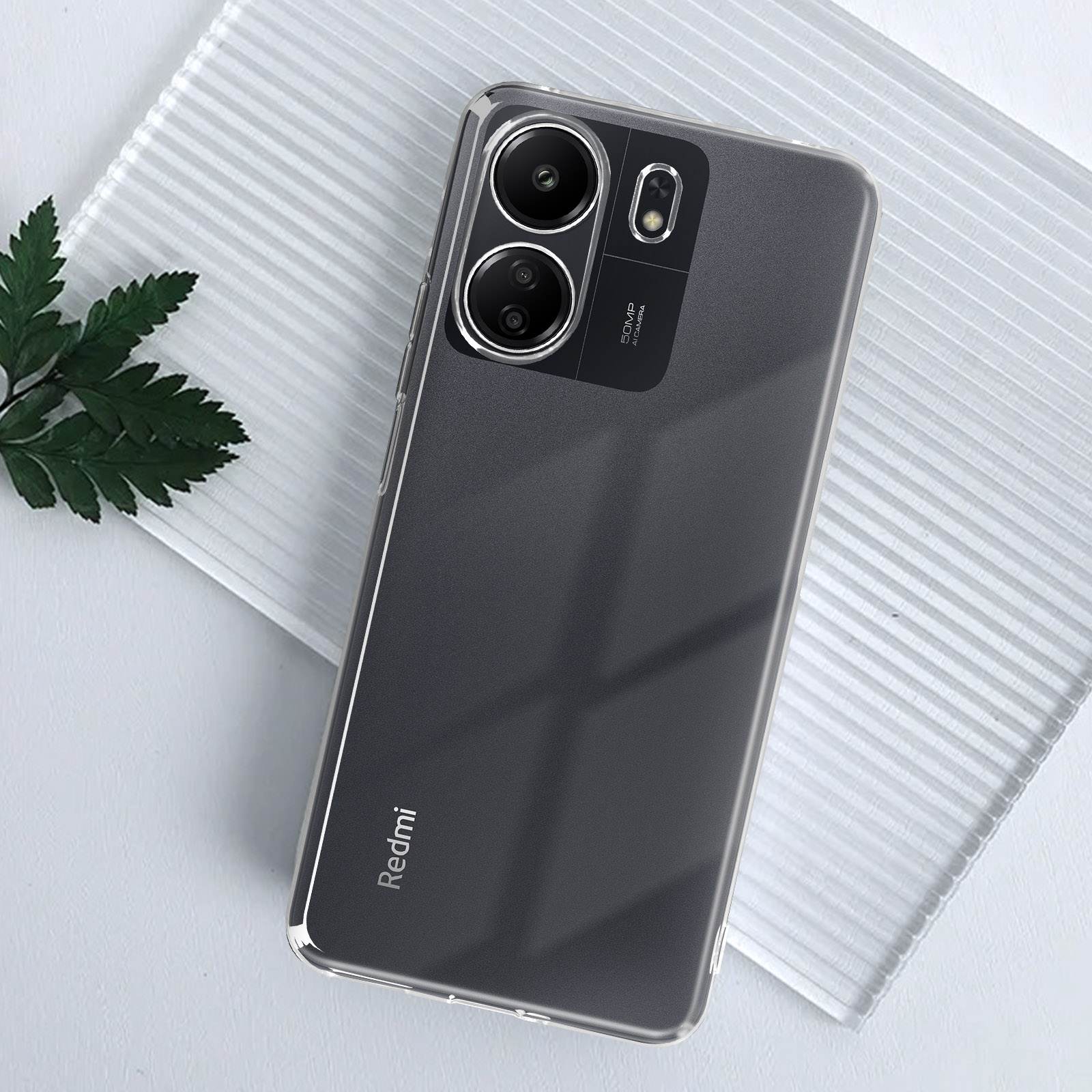 Una custodia trasparente per telefono con un telefono all'interno. Il telefono ha tre fotocamere e il logo Redmi.
