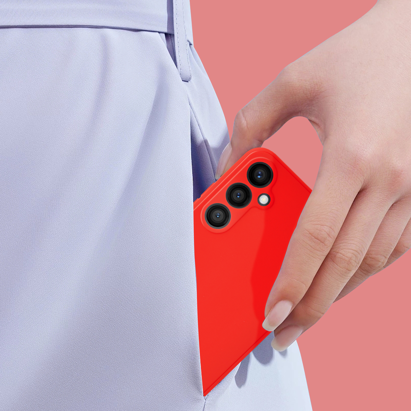 Mano che tiene un telefono rosso, parzialmente in tasca, su sfondo rosa.