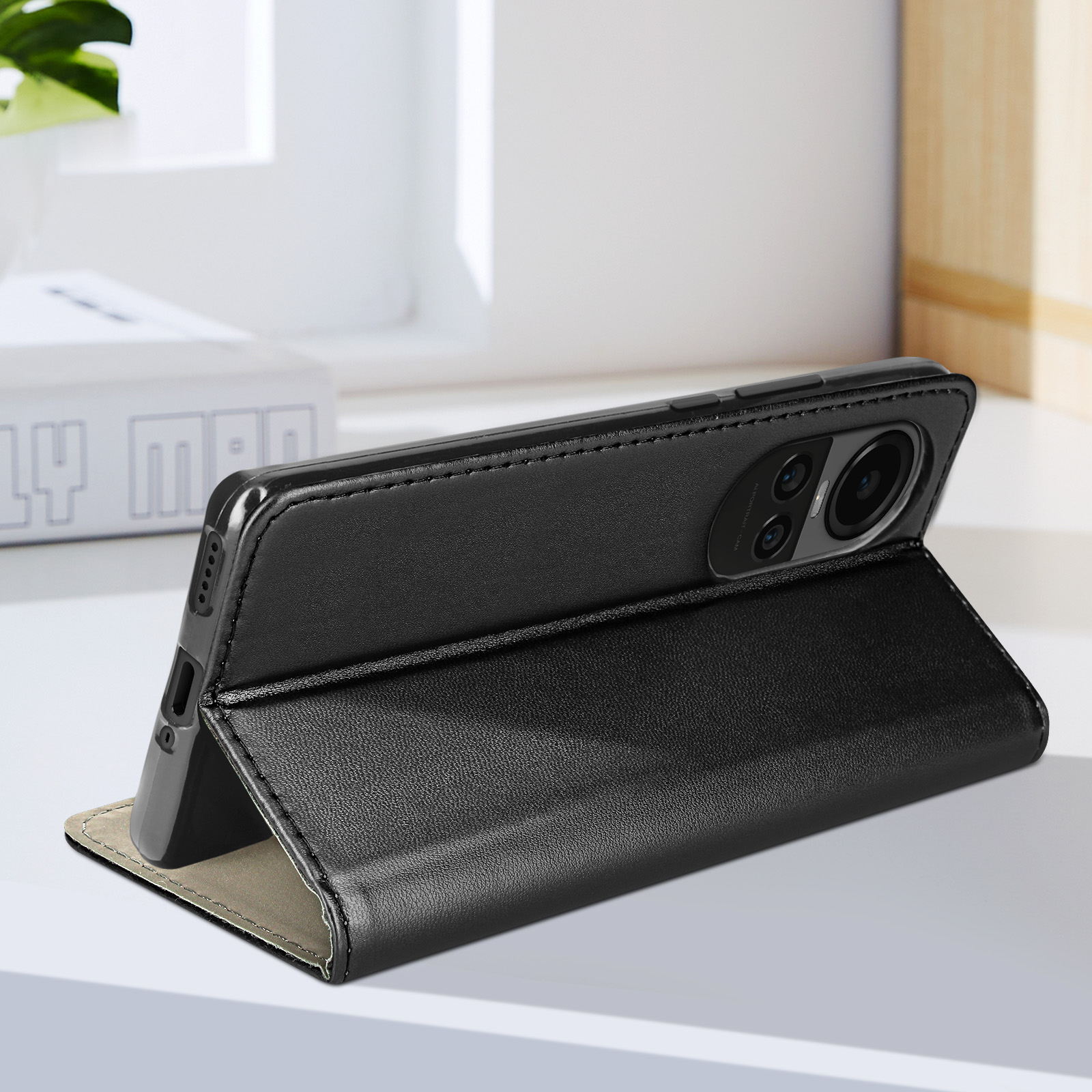 Eine schwarze Handyhülle ist offen und lehnt an einer weißen Oberfläche. Ein Telefon befindet sich darin. Weißer Hintergrund.