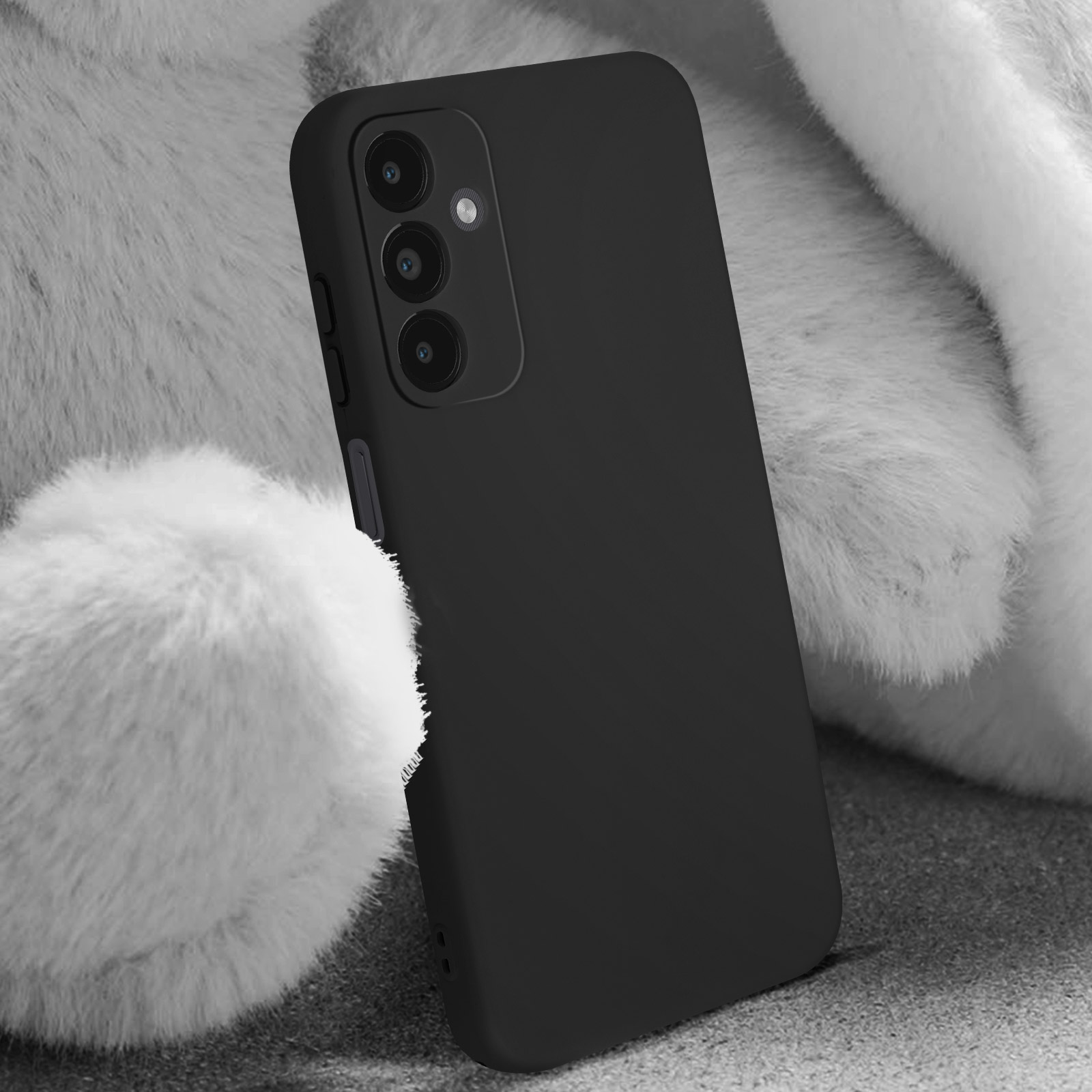 Uno smartphone nero in una custodia nera, con uno sfondo bianco e soffice.