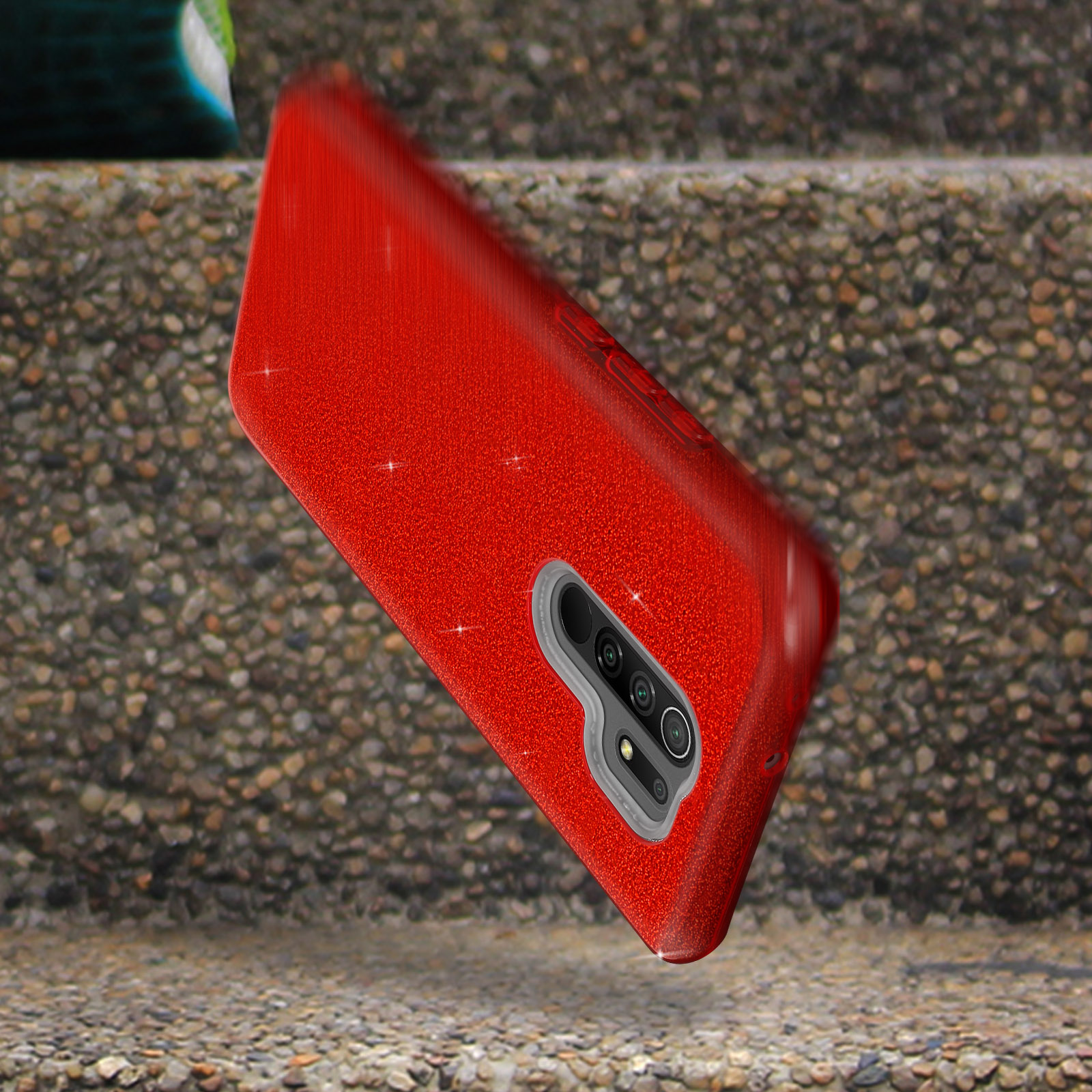 Een rode telefoonhoes met glitter op een stenen trap. De camera is zichtbaar.