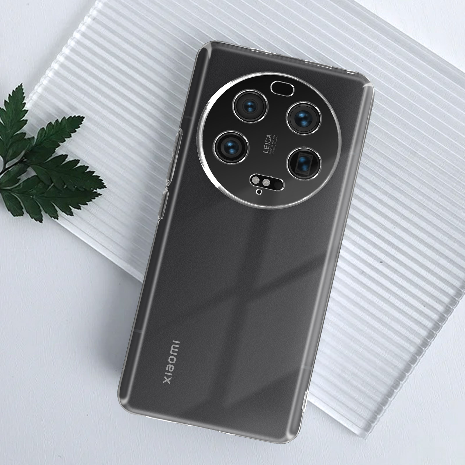 Retro di un telefono con custodia trasparente. Il telefono ha più lenti della fotocamera. Testo: Xiaomi, Leica.