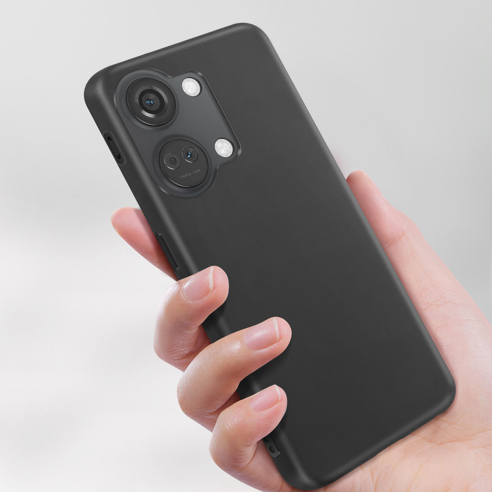 Mano che tiene una custodia per telefono nera con tre fotocamere. Sfondo bianco.