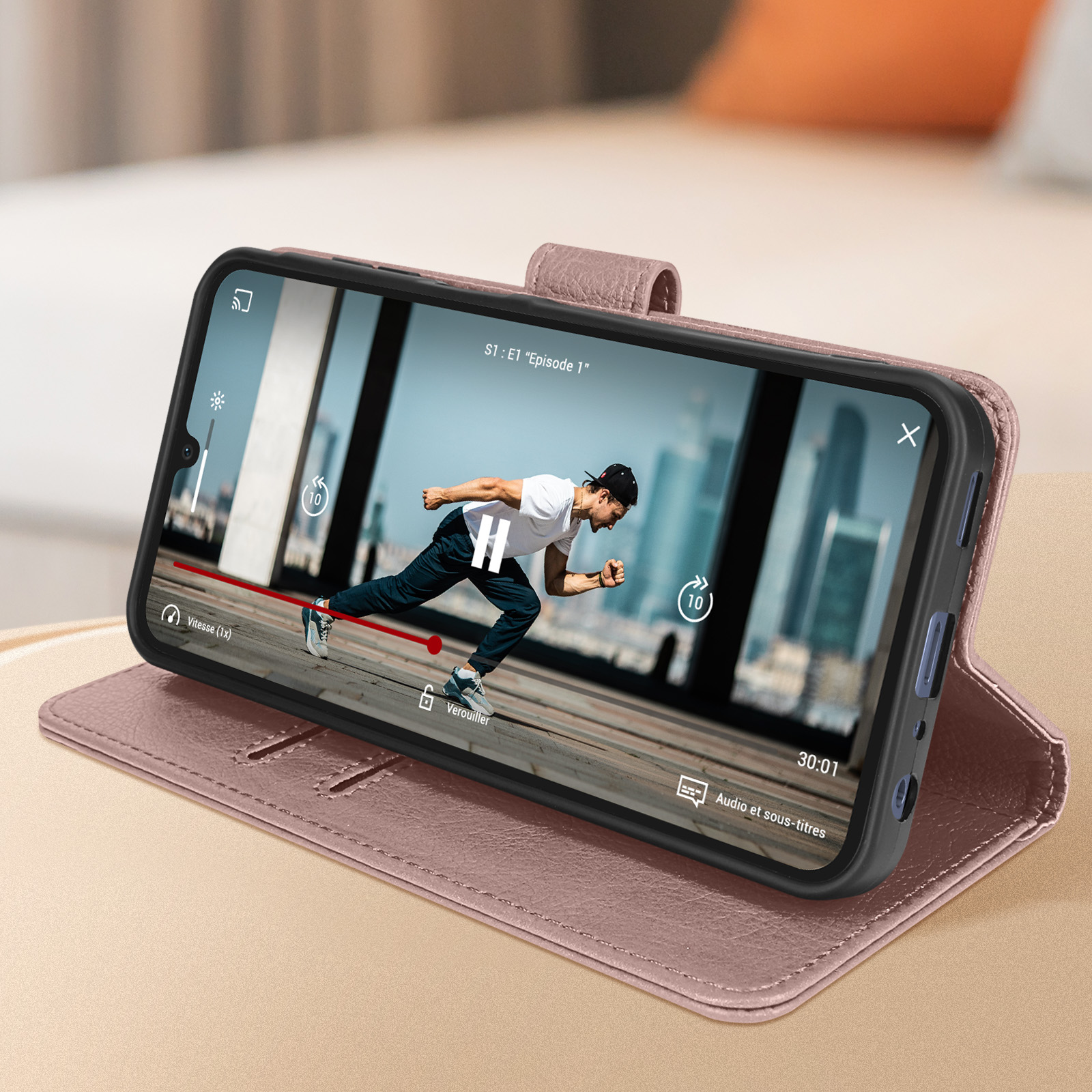 Un telefono in una custodia rosa mostra un video di un uomo che corre. Controlli di riproduzione.