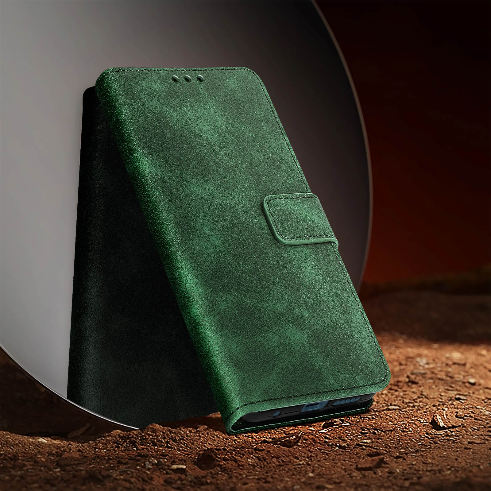 Custodia per telefono in pelle verde. È aperta, rivelando un telefono all'interno. Uno specchio sullo sfondo.
