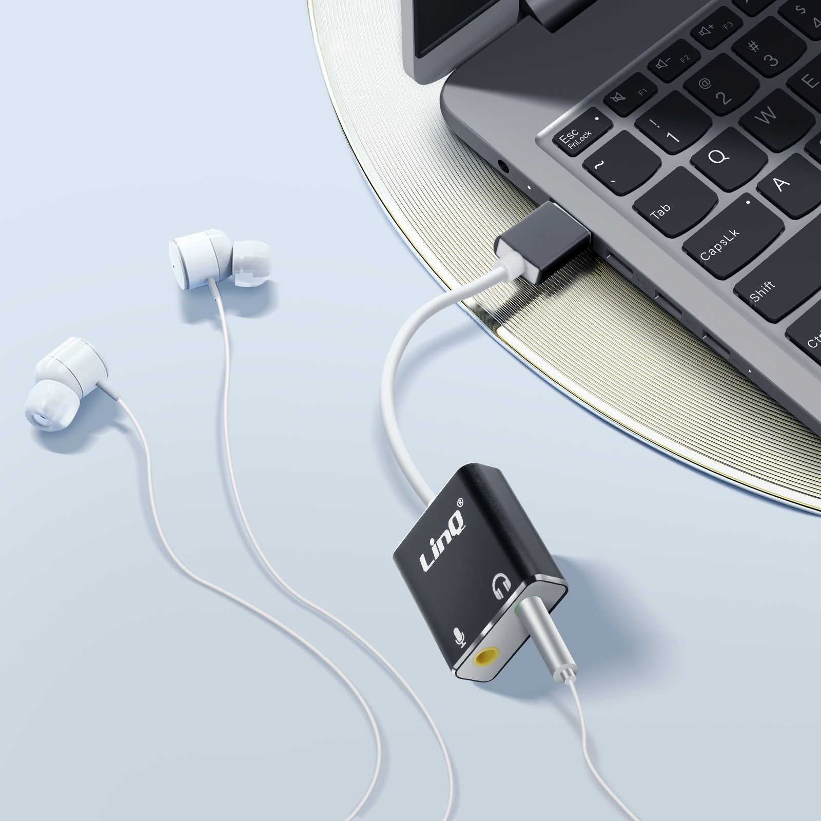 Un laptop, cuffie e un adattatore che li collega. Schema di colori bianco e nero.