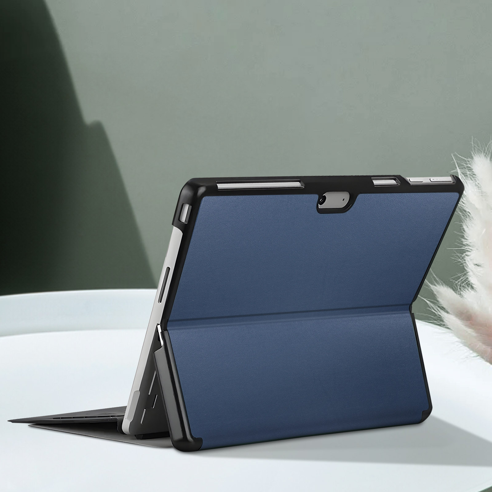 Étui de tablette bleu, plié ouvert, sur une surface blanche.